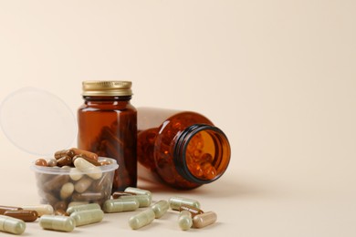 Pharmacist. Many different pills in plastic container and bottles on beige background, space for text