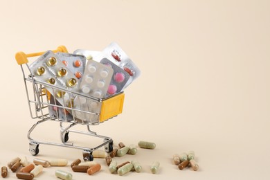 Photo of Pharmacist. Many different pills in small shopping cart on beige background