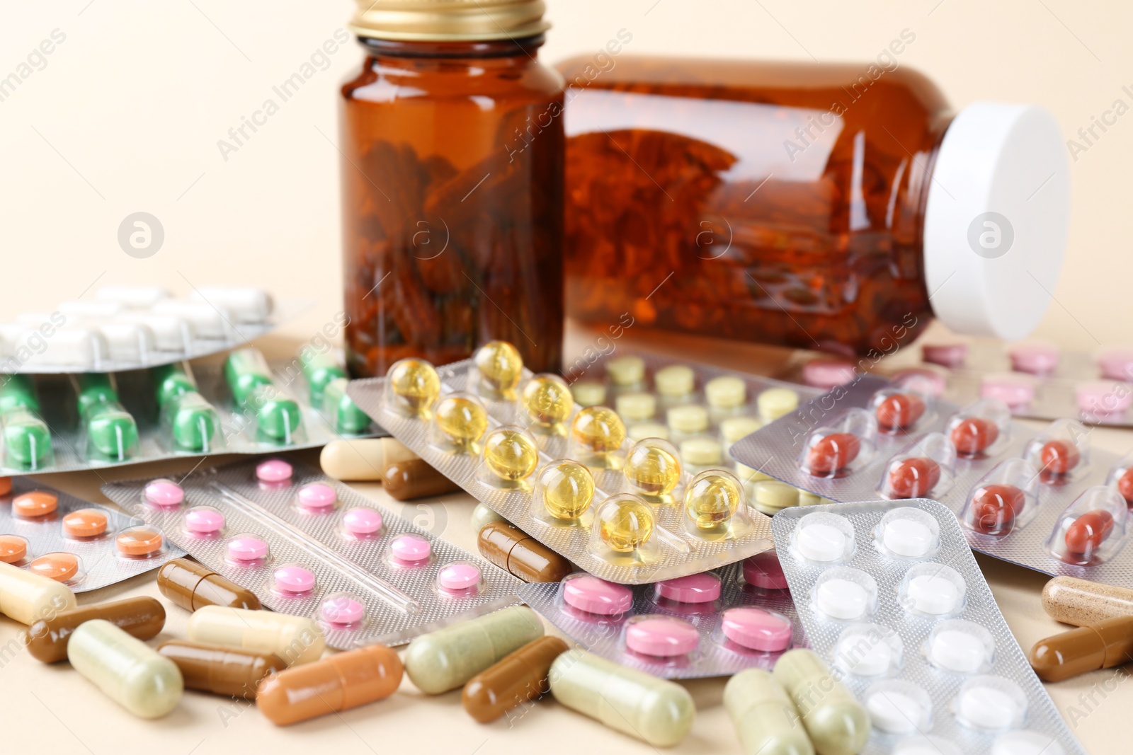 Photo of Pharmacist. Many different pills on beige background, closeup