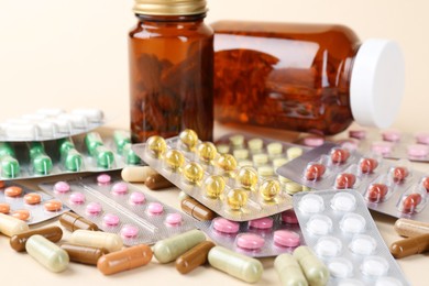 Photo of Pharmacist. Many different pills on beige background, closeup