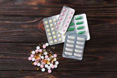 Photo of Pharmacist. Many different pills on wooden table, flat lay