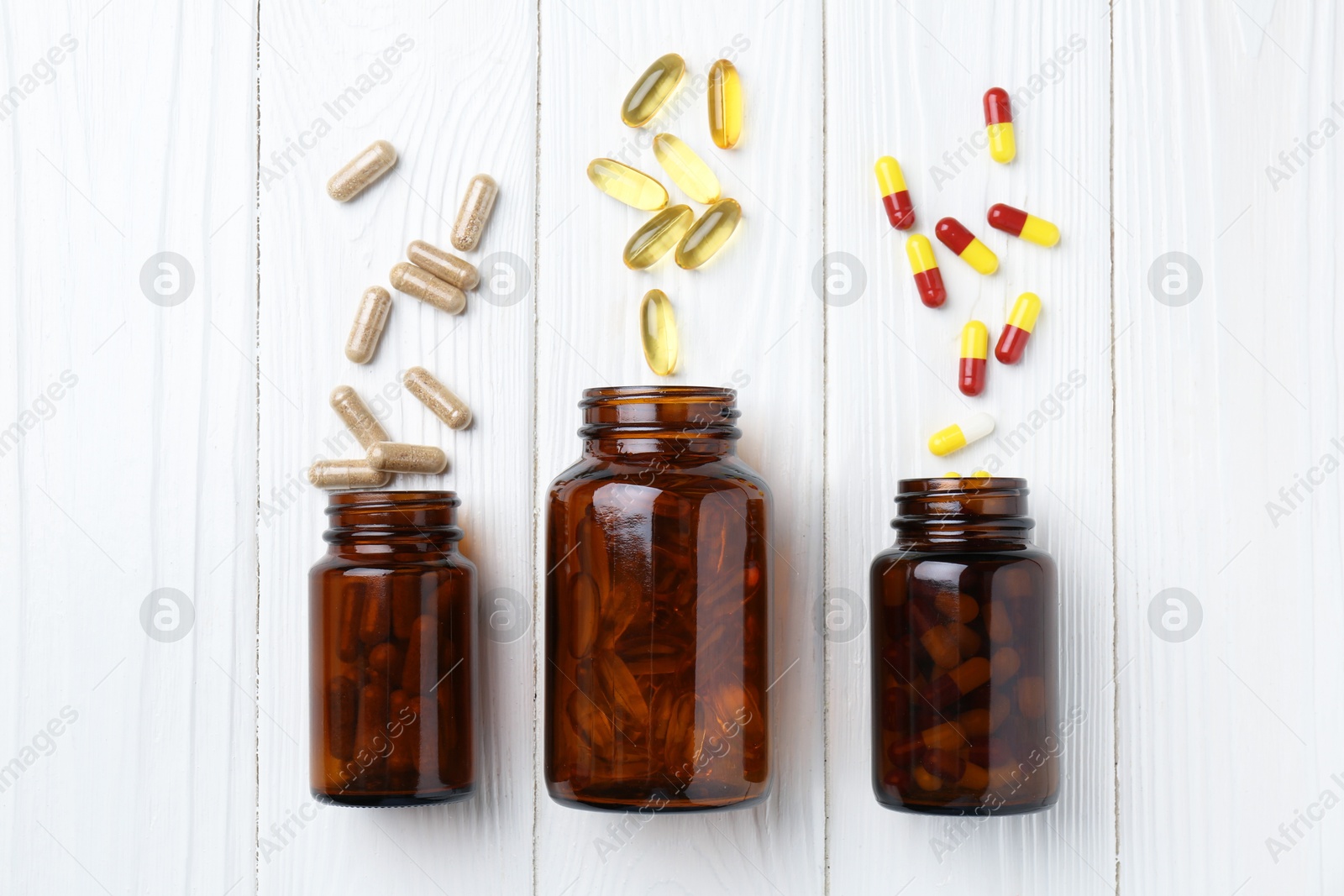 Photo of Pharmacist. Many different pills and overturned bottles on white wooden table, flat lay