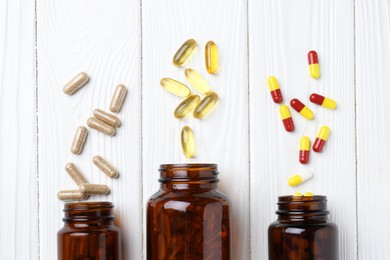 Photo of Pharmacist. Many different pills and overturned bottles on white wooden table, flat lay