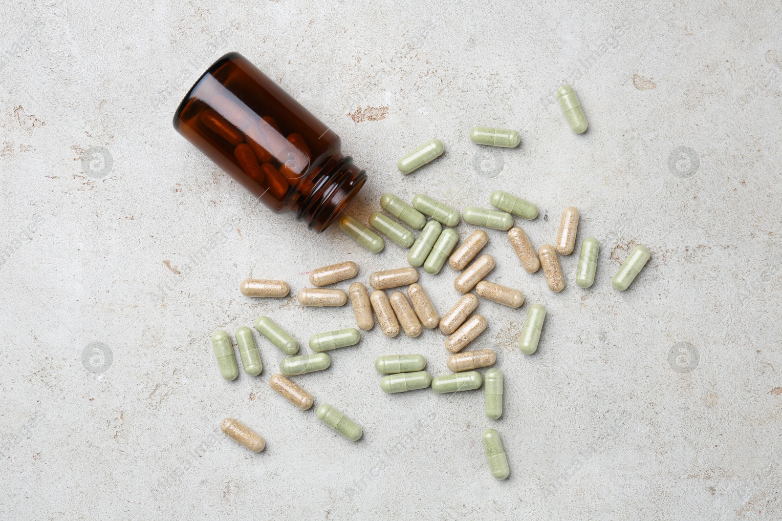 Photo of Pharmacist. Many different pills and overturned bottle on grey table, flat lay