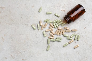 Photo of Pharmacist. Many different pills and overturned bottle on grey table, flat lay. Space for text