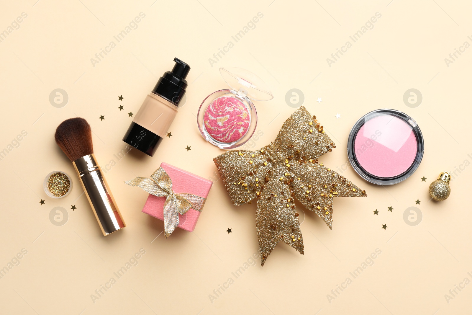 Photo of Flat lay composition with makeup products and Christmas decor on beige background