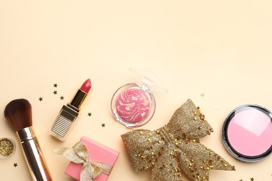 Flat lay composition with makeup products and Christmas decor on beige background. Space for text