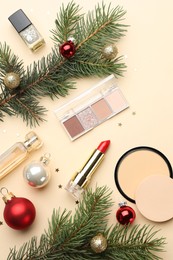 Photo of Flat lay composition with makeup products and Christmas decor on beige background