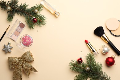 Photo of Frame made of makeup products and Christmas decor on beige background, flat lay. Space for text