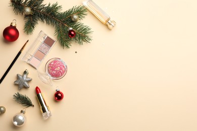 Photo of Flat lay composition with makeup products and Christmas decor on beige background. Space for text