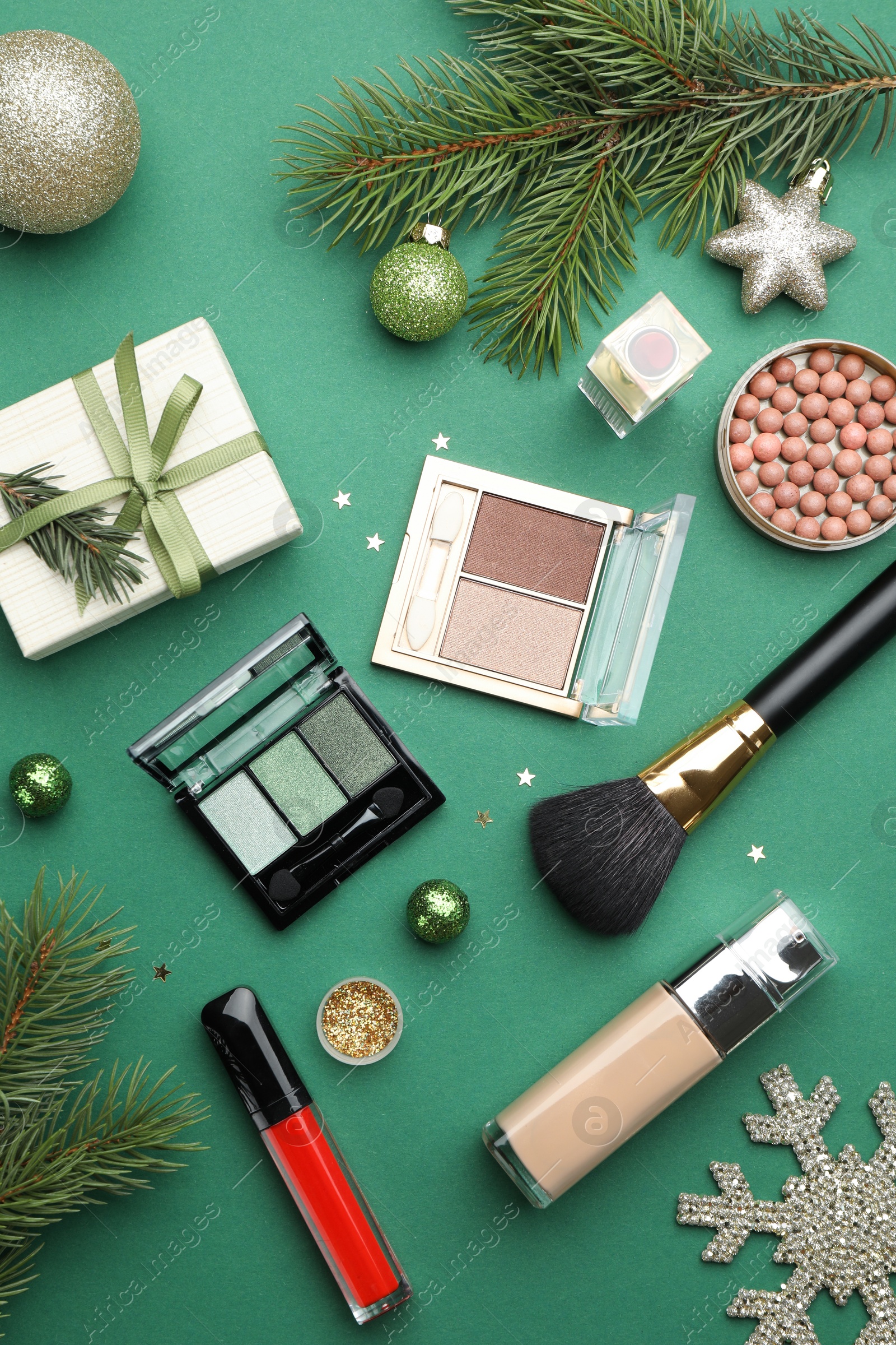 Photo of Flat lay composition with makeup products and Christmas decor on green background