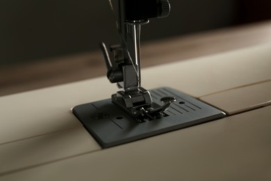 Photo of Modern sewing machine on light background, closeup