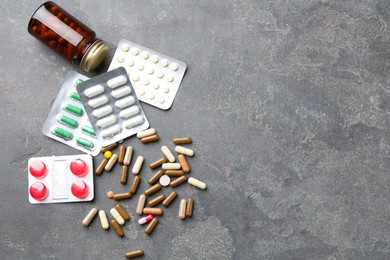 Photo of Pharmacist. Different pills and plastic bottle on grey table, flat lay. Space for text