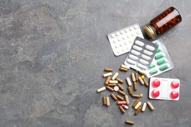 Photo of Pharmacist. Different pills and plastic bottle on grey table, flat lay. Space for text