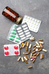 Pharmacist. Different pills and plastic bottle on grey table, flat lay