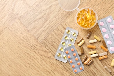 Photo of Pharmacist. Different pills on wooden table, flat lay. Space for text