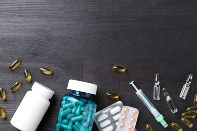 Photo of Pharmacist. Different pills, bottles, syringe and ampoules on grey wooden table, flat lay. Space for text