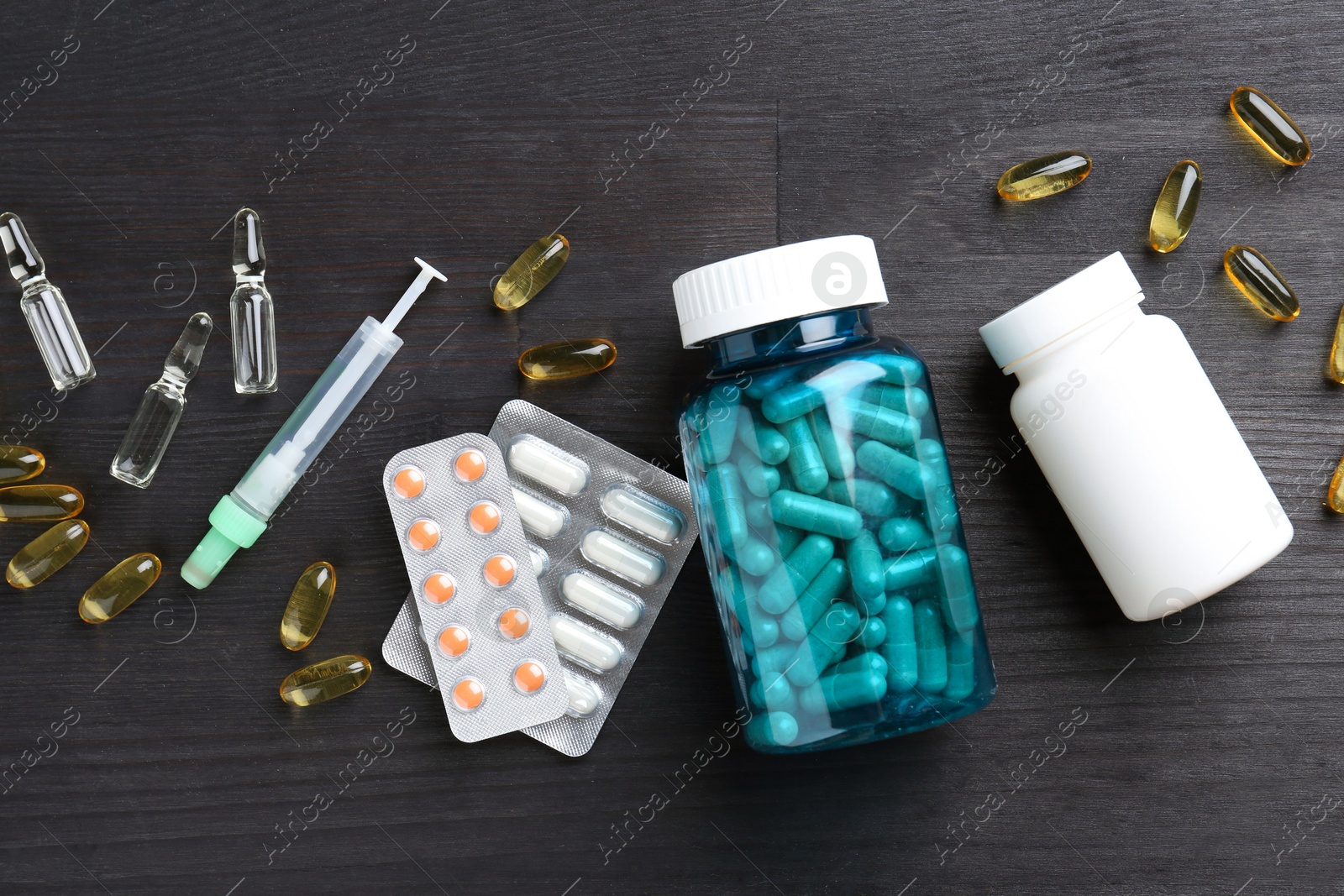 Photo of Pharmacist. Different pills, plastic bottles, syringe and ampoules on grey wooden table, flat lay