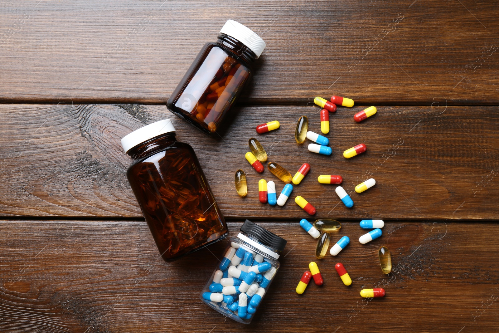 Photo of Pharmacist. Different pills and plastic bottles on wooden table, flat lay