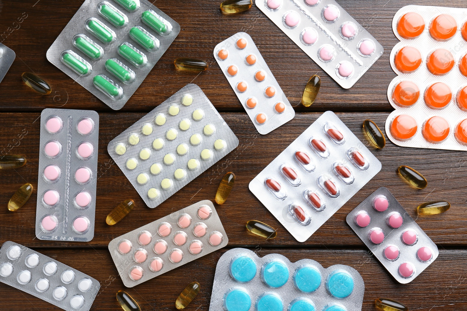 Photo of Pharmacist. Different pills on wooden table, flat lay