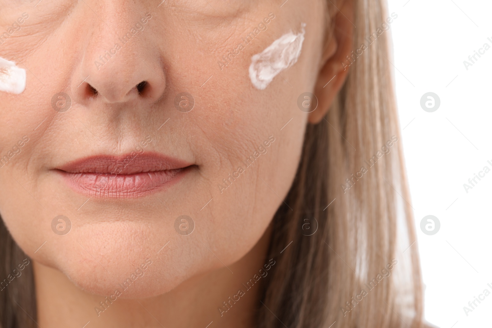 Photo of Senior woman with face cream on white background, closeup