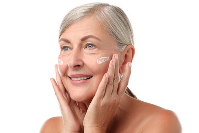 Photo of Senior woman with face cream on white background