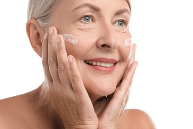 Photo of Senior woman with face cream on white background, closeup