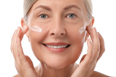 Senior woman with face cream on white background, closeup