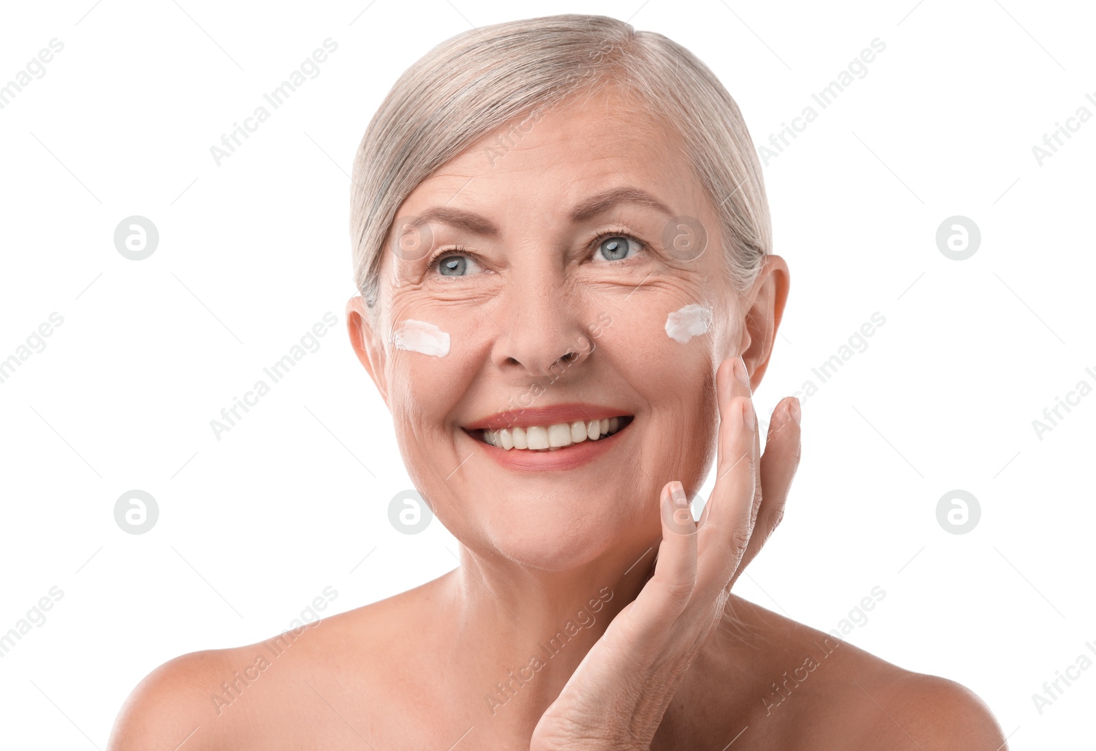 Photo of Senior woman applying face cream on white background