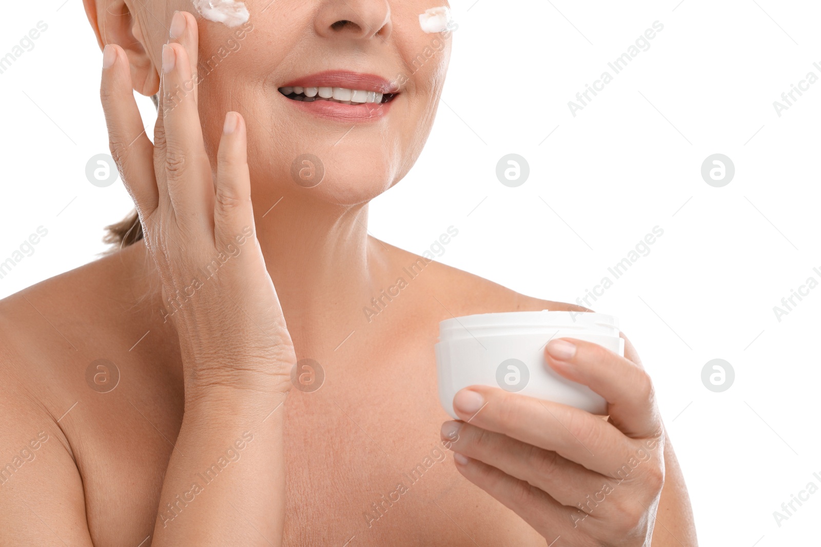 Photo of Senior woman applying face cream on white background, closeup