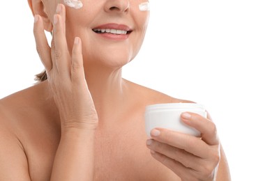 Photo of Senior woman applying face cream on white background, closeup