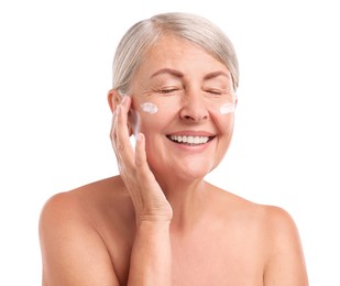 Senior woman with face cream on white background