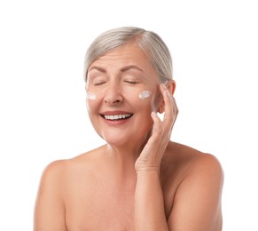 Senior woman with face cream on white background