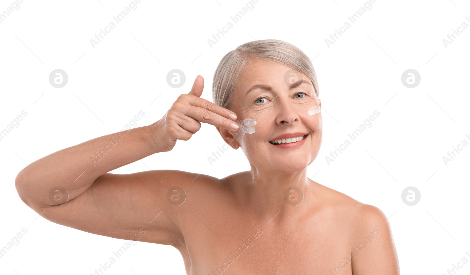 Photo of Senior woman applying face cream on white background