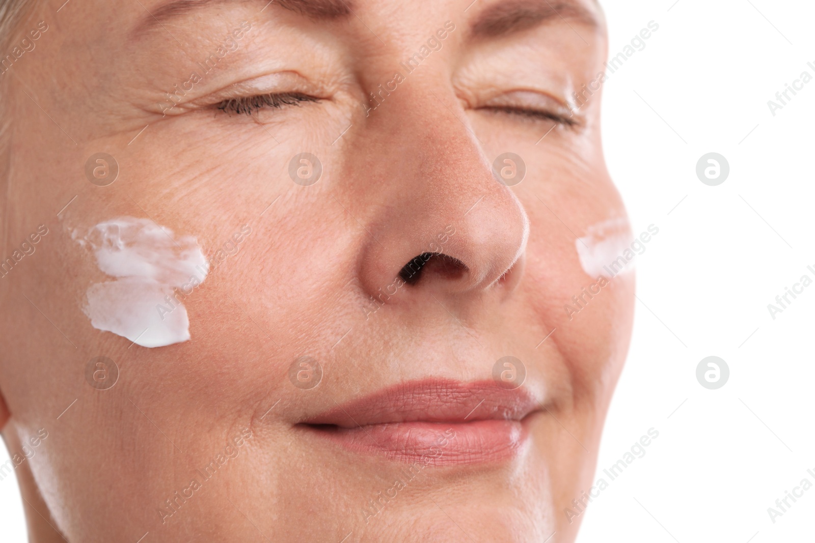 Photo of Senior woman with face cream on white background, closeup