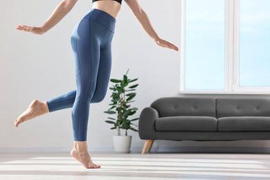 Photo of Woman wearing blue sports leggings in room, closeup