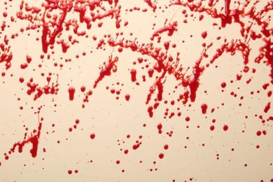 Photo of Splashes of red blood on beige background