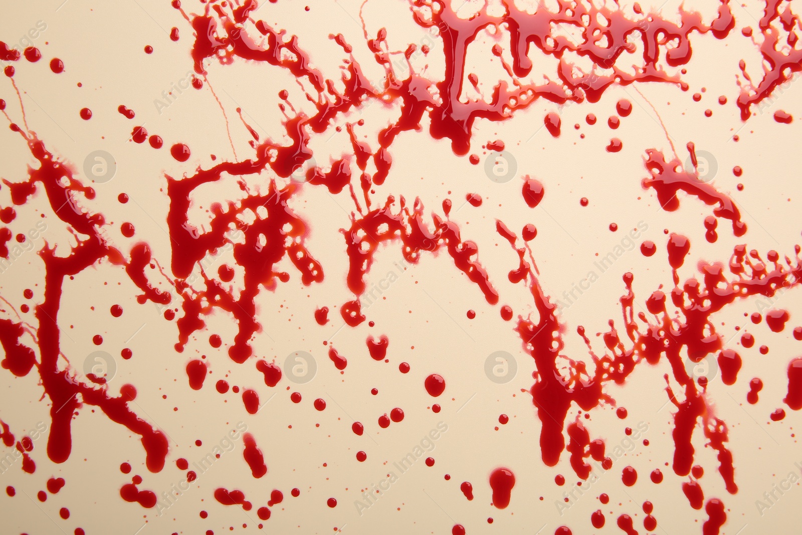 Photo of Splashes of red blood on beige background