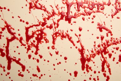 Splashes of red blood on beige background