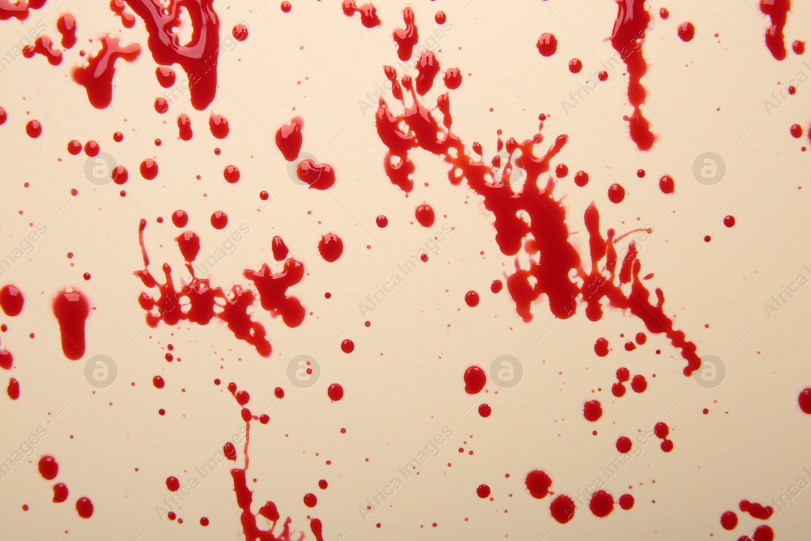 Photo of Splashes of red blood on beige background