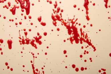 Photo of Splashes of red blood on beige background