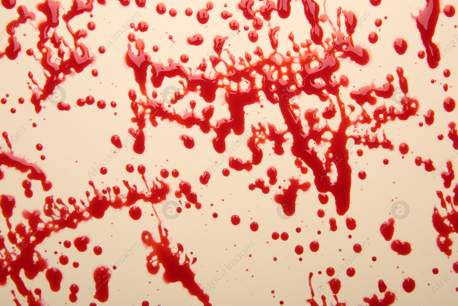 Photo of Splashes of red blood on beige background