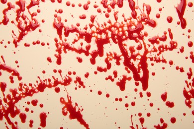 Splashes of red blood on beige background