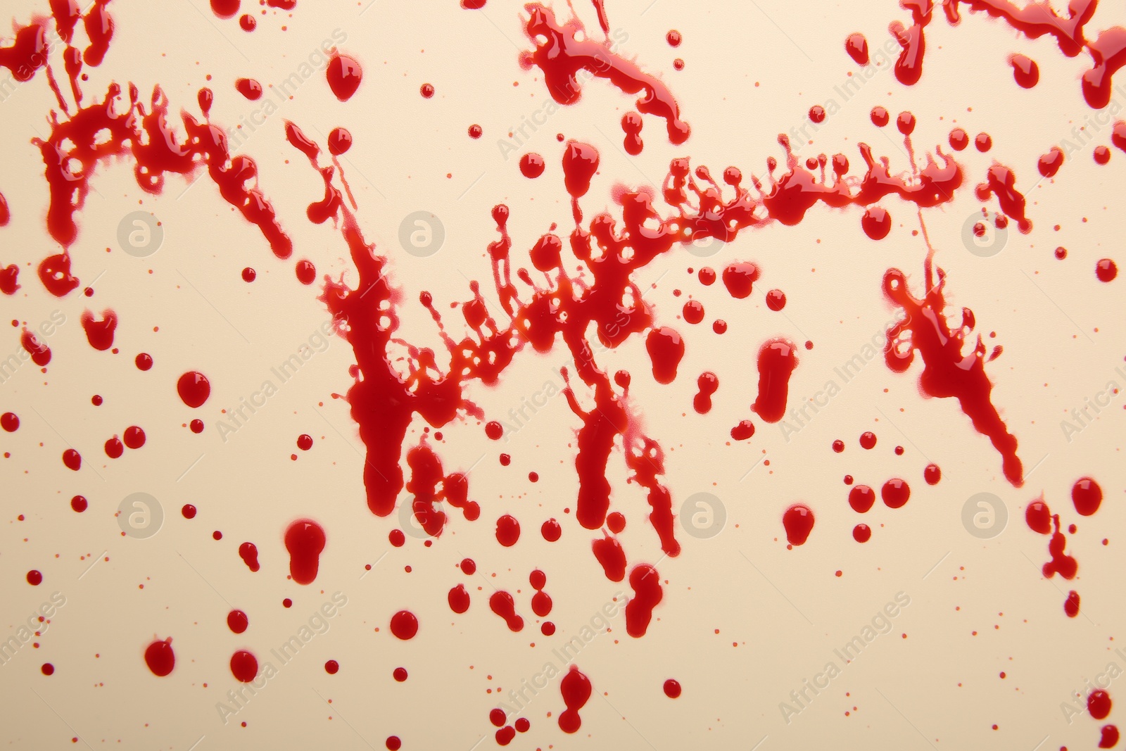 Photo of Splashes of red blood on beige background