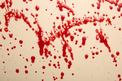 Splashes of red blood on beige background