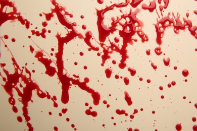 Photo of Splashes of red blood on beige background