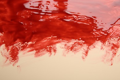 Photo of Stain of blood on beige background, closeup