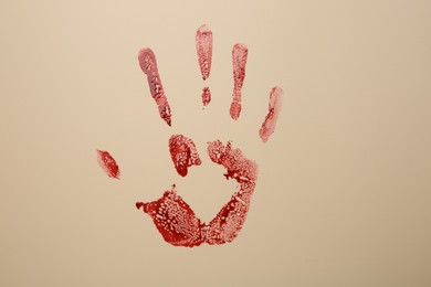 Photo of Bloody hand print of human on beige background