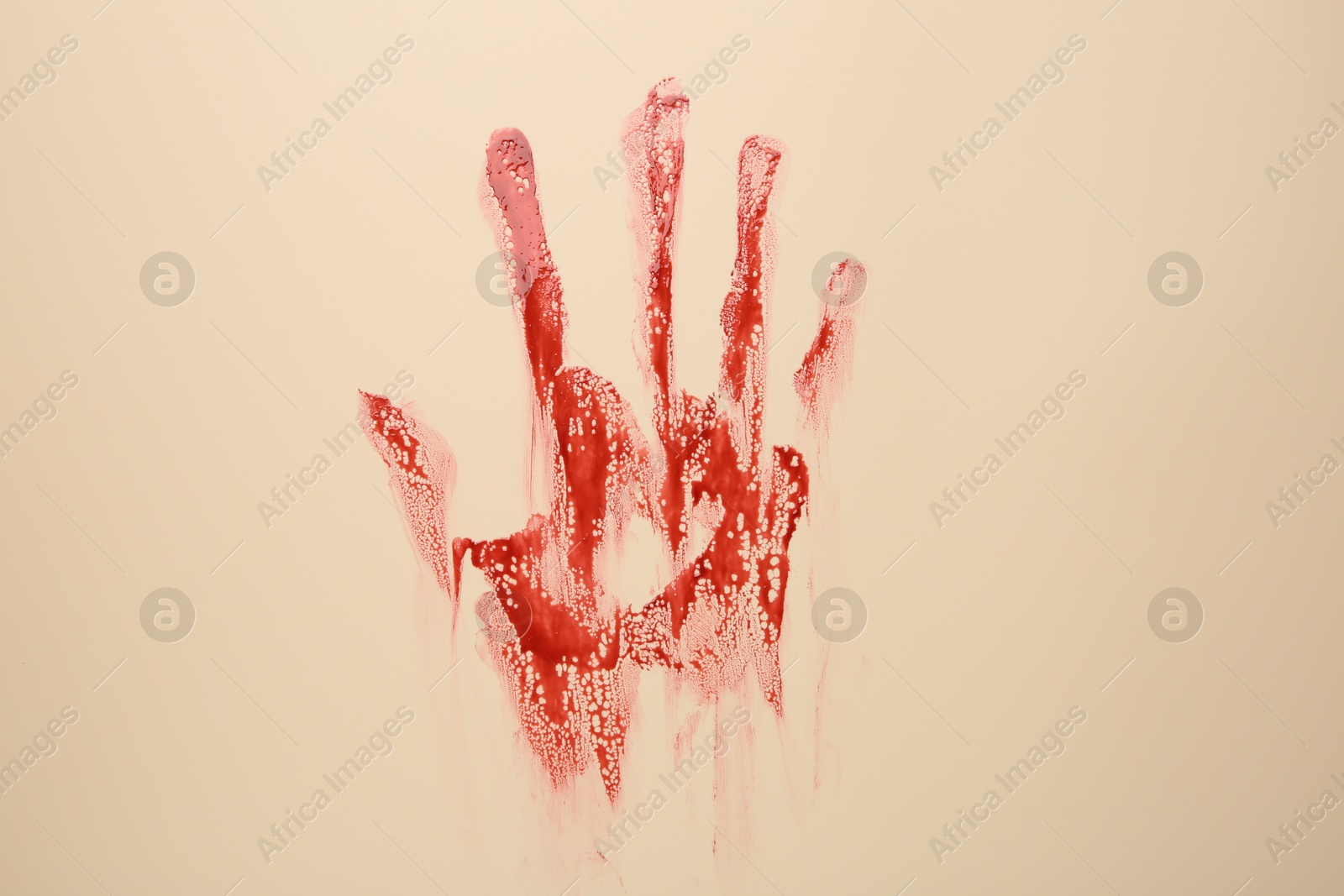 Photo of Bloody hand print of human on beige background