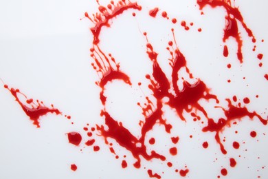 Photo of Splashes of red blood on white background